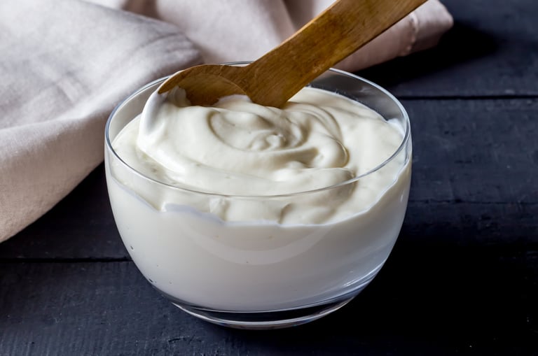 Yogurt in bowl on rustic black table - Photo of plain natural organic yoghurt close up