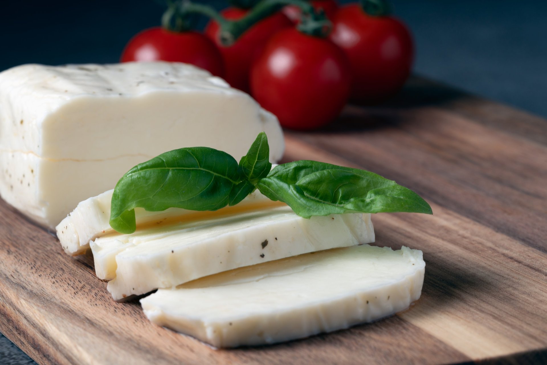 Close up of halloumi cheese slices with fresh basil and tomatoes